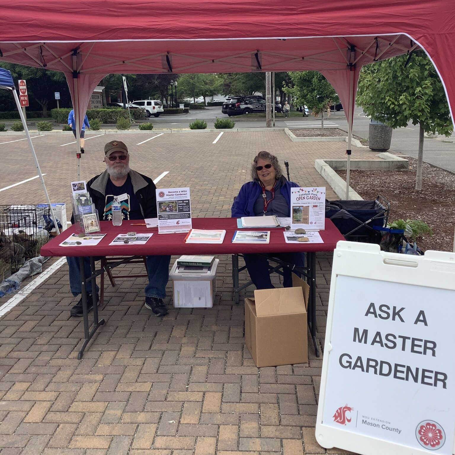 Volunteers at farmers market booth with Ask a Master Gardener sign.