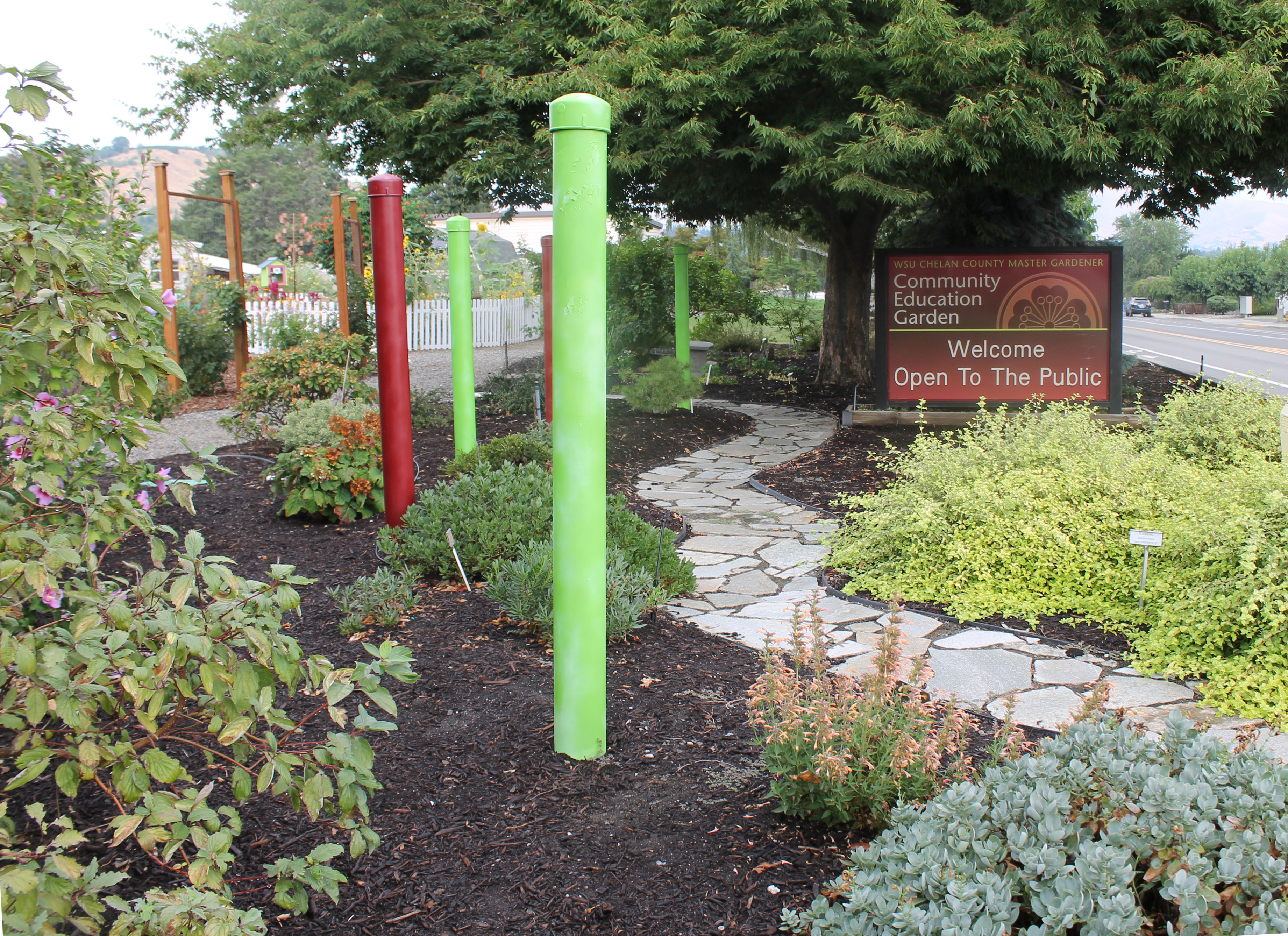 Community education garden entrance with landscaped path and welcome sign.