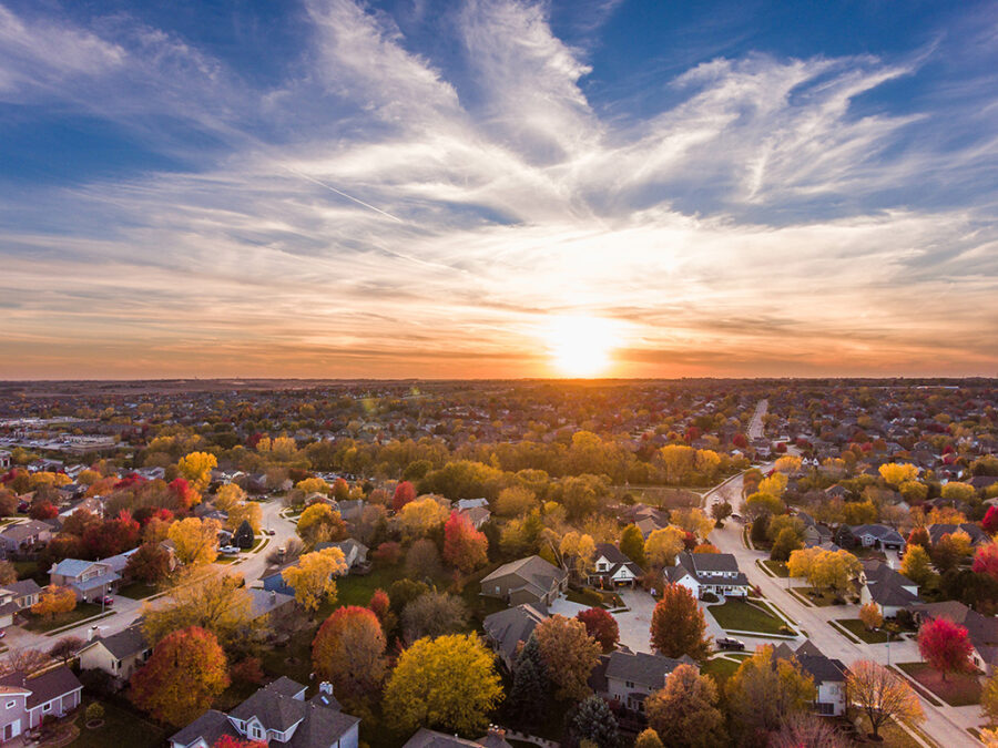 aerial picture of a neighborhood in fall with a sunset and clouds