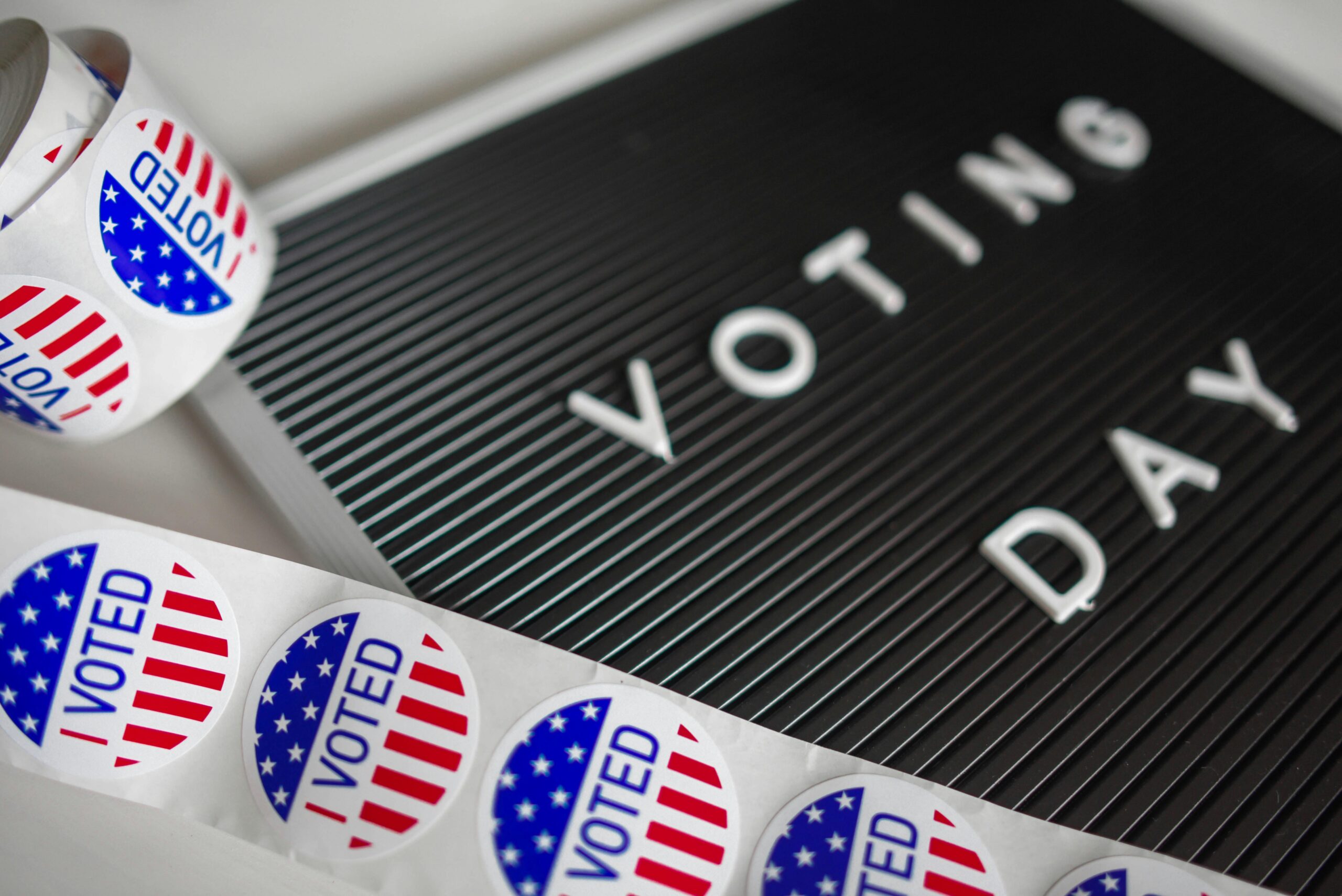 A sign that says "voting day" and a roll of "I voted" stickers.