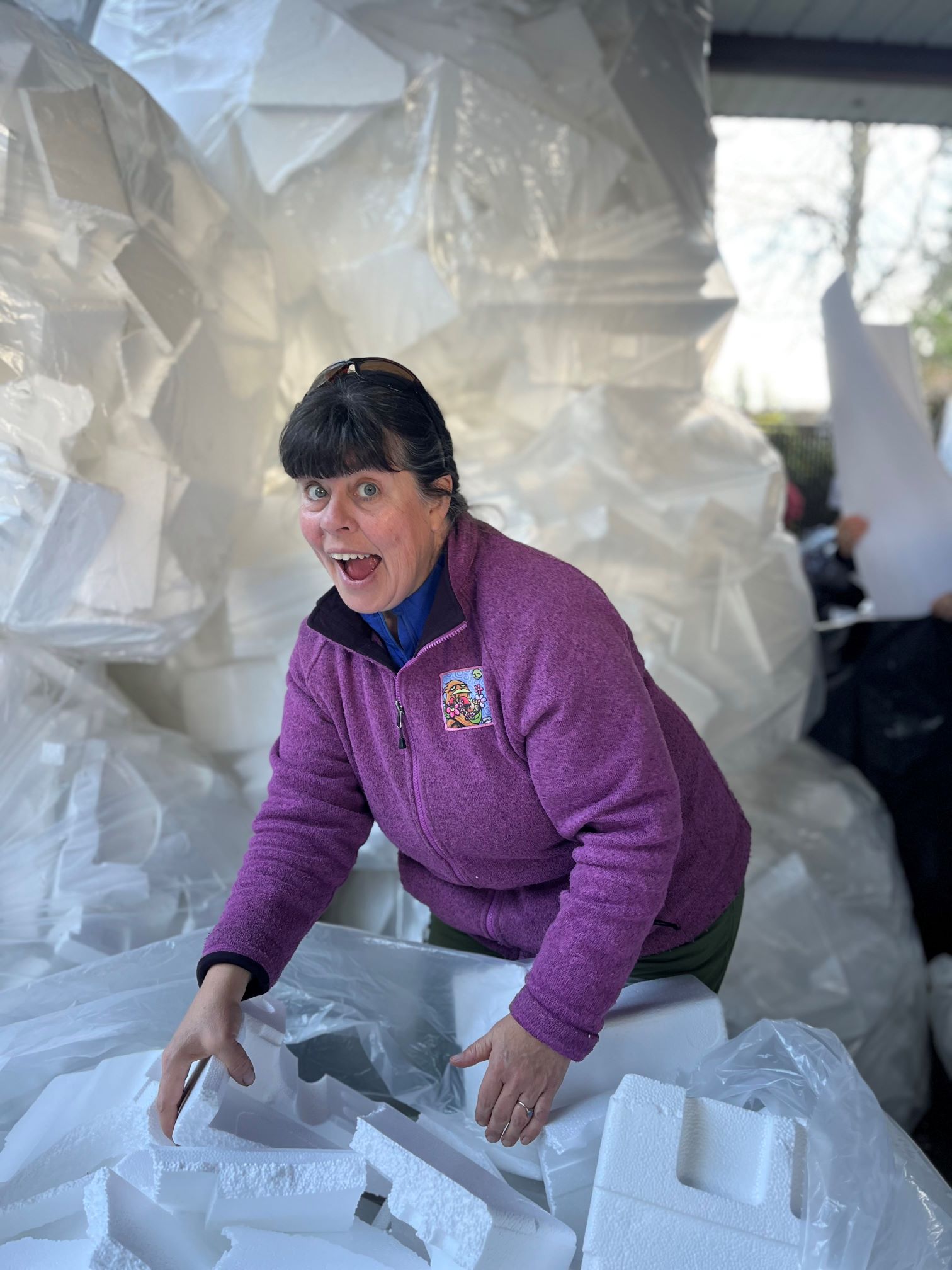 Woman in purple surrounded by piles of Styrofoam