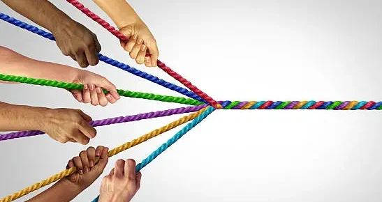 Six hands holding onto rope