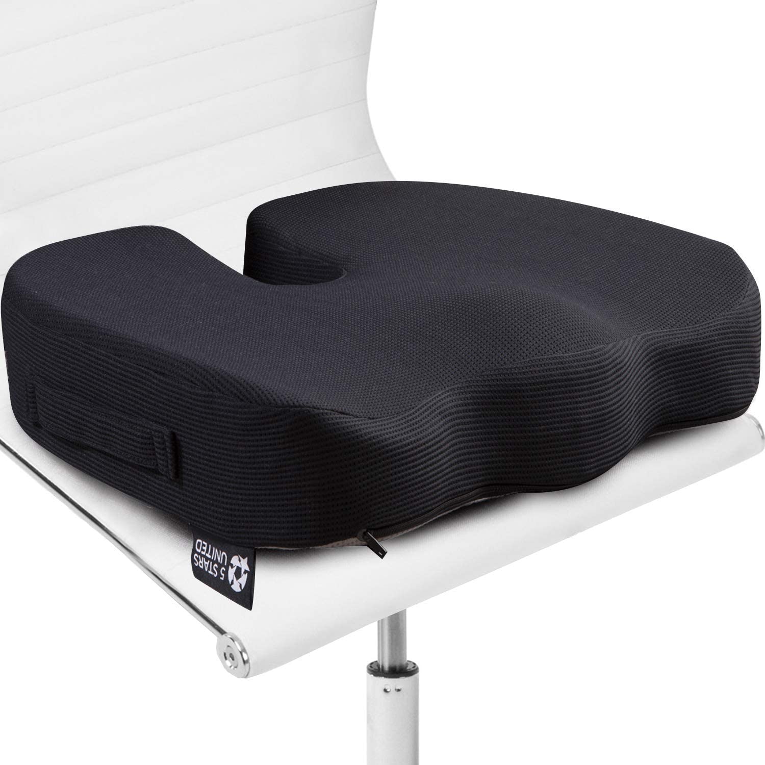 Black memory foam seat cushion with U-shaped cutout placed on a white chair.