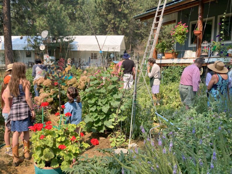 Kids and adults viewing a Ferry County community member's garden on the Master Gardener Ferry County Summer Garden Tour.