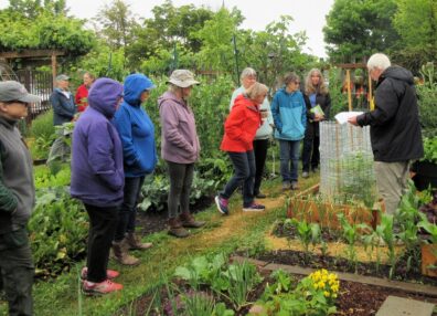 Participants listen to a Master Gardener presentation at the 5th Street Community Garden.