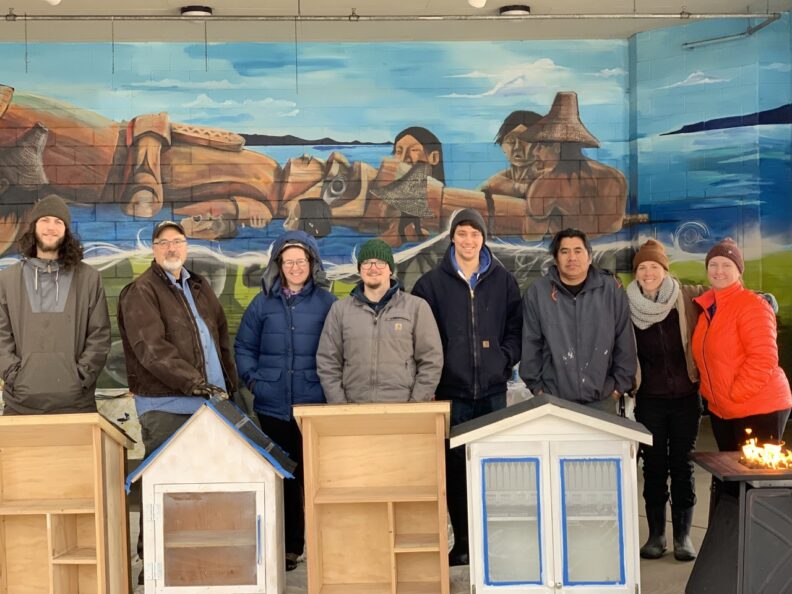 Group of people standing behind newly built pantries