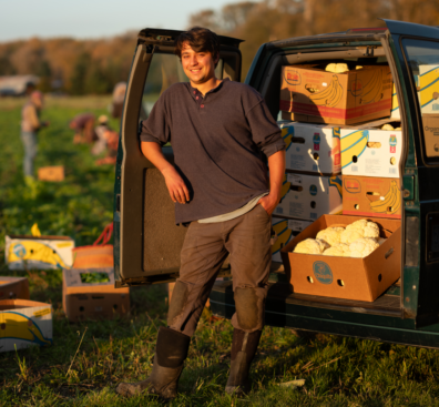 Farm gleaning program leader standing by the work van.