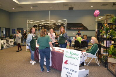 Master Gardeners sitting at an info booth at the Soroptimist Gala Garden Show.