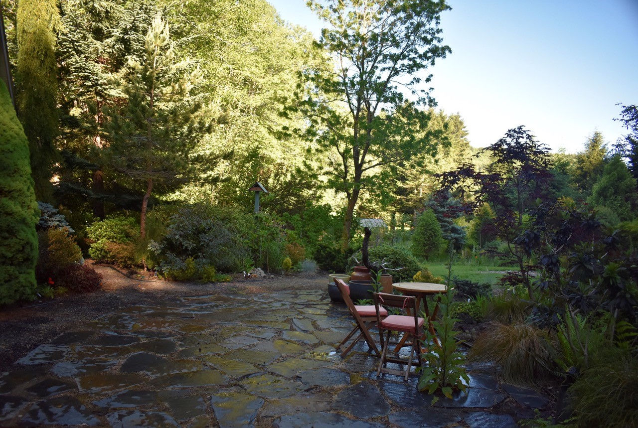 Flagstone patio with table and chairs with outside garden view