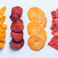 Slices of dried fruits arranged in rows on a light background.