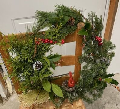 Seasonal wreath with cones and berries resting on a chair