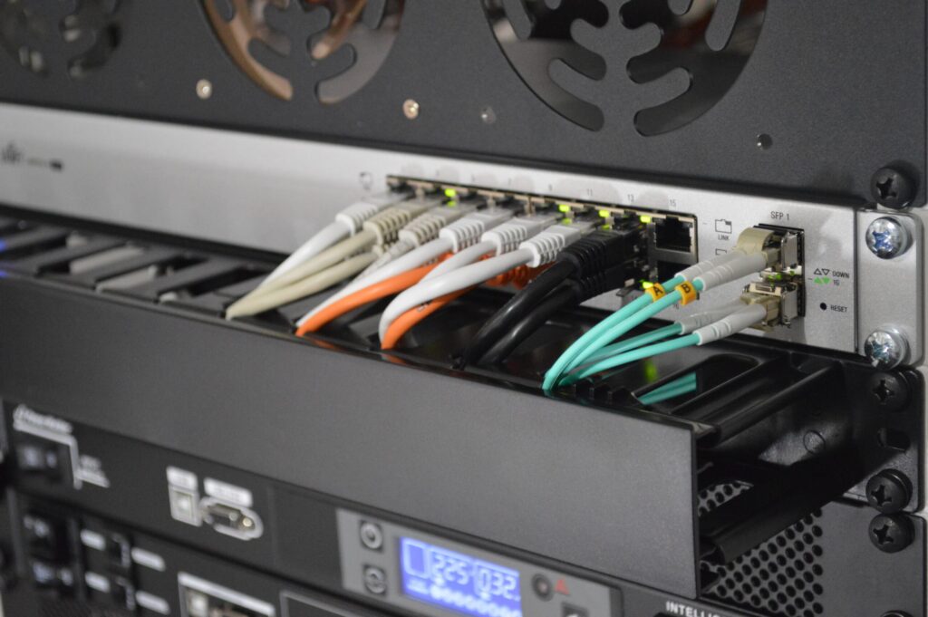 Network cables connected to a switch in a server rack with active data connections.