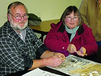 Two Master Gardener volunteers working together at a table with gardening materials