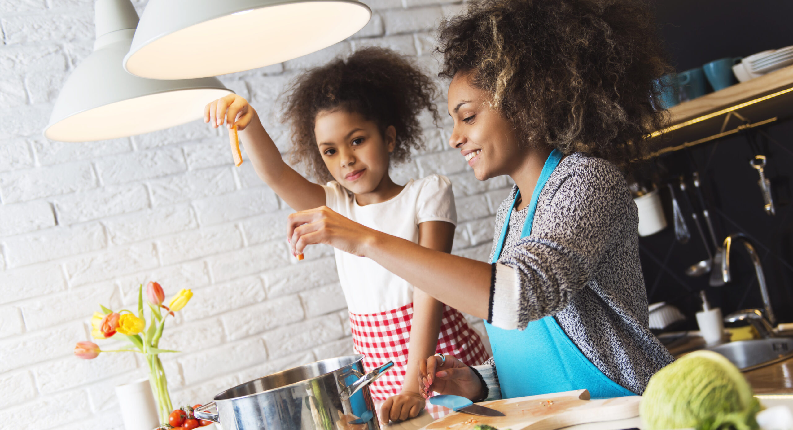 African American woman and her daughter cooking in the kitchen