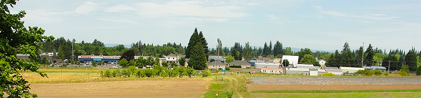 iew of 78th Street Heritage Farm with open fields, crops, and surrounding buildings in a rural landscape.