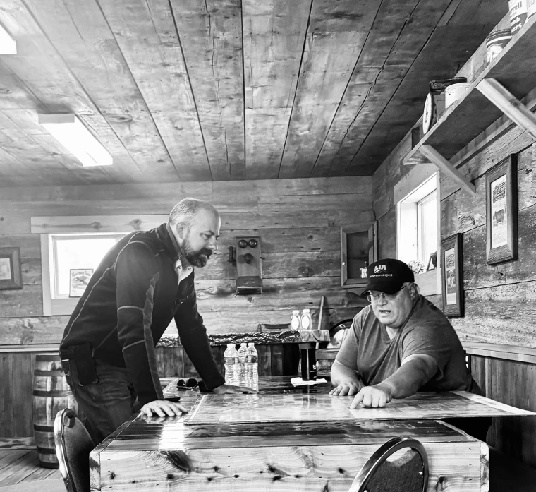 Two men at a table looking at a map.