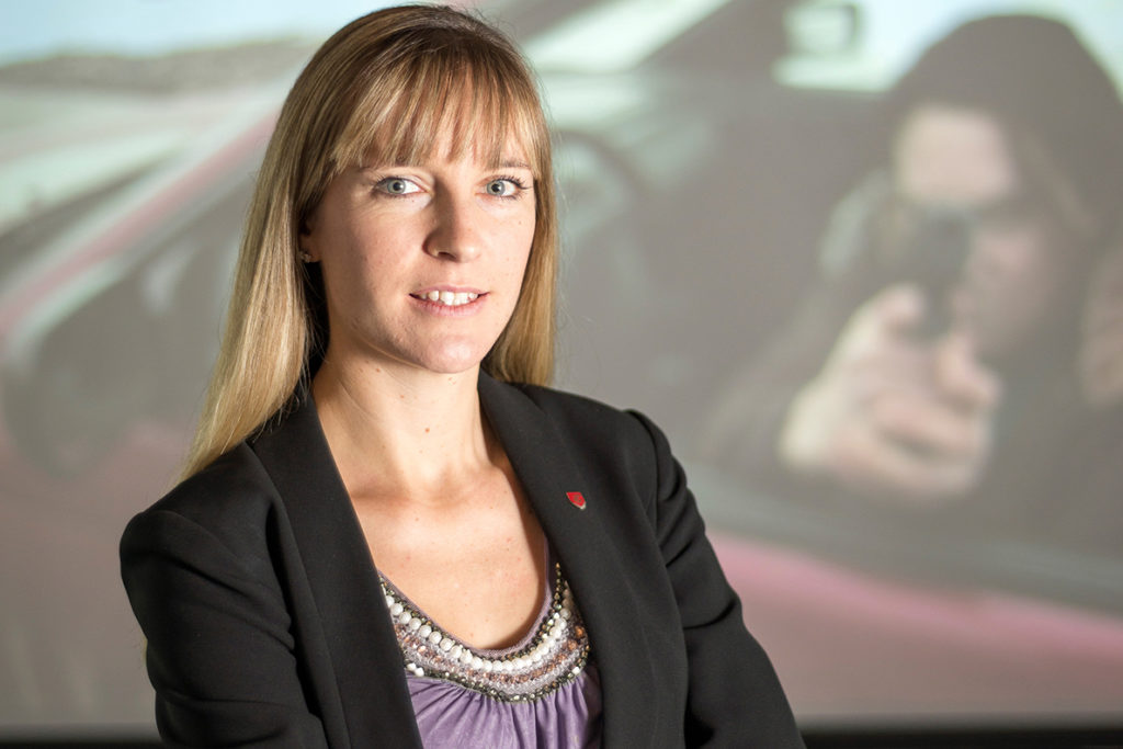 Lois James standing before a video screen