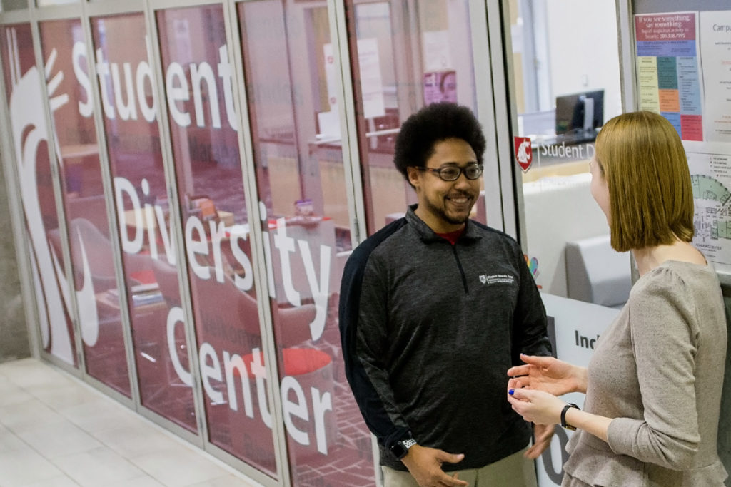 Students standing outside the new lounge and offices for WSU Spokane's offices of Community Engagement and Service Learning, Student Leadership and Involvement, and the Student Diversity Center.