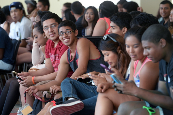 Students in an assembly, with one student in the middle looking at the camera smiling