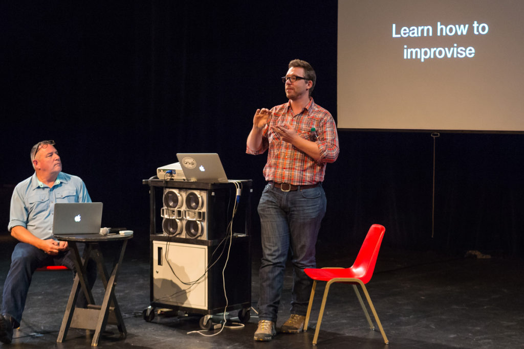 Tremper on stage in front of a projector
