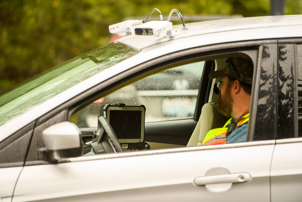 License plate reader cameras are mounted atop a parking enforcement vehicle with an onboard computer screen installed near the driver.