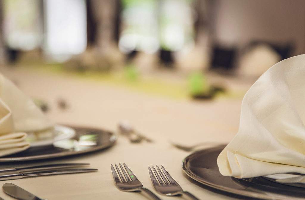 An empty table with place settings on it.