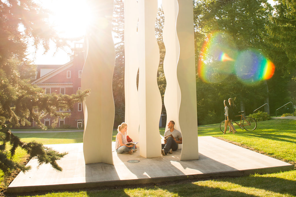 Two people enjoying sunshine on the campus lawn.