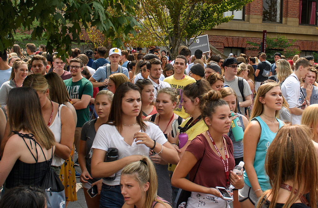 Hundreds of students standing shoulder to shoulder outside.