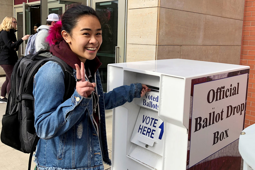 Student dropping ballot off in official ballot box.