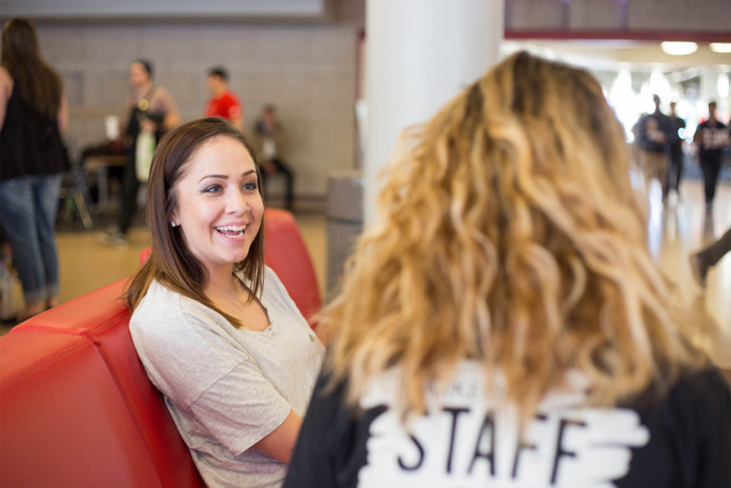 Student speaks with a staff member on campus.