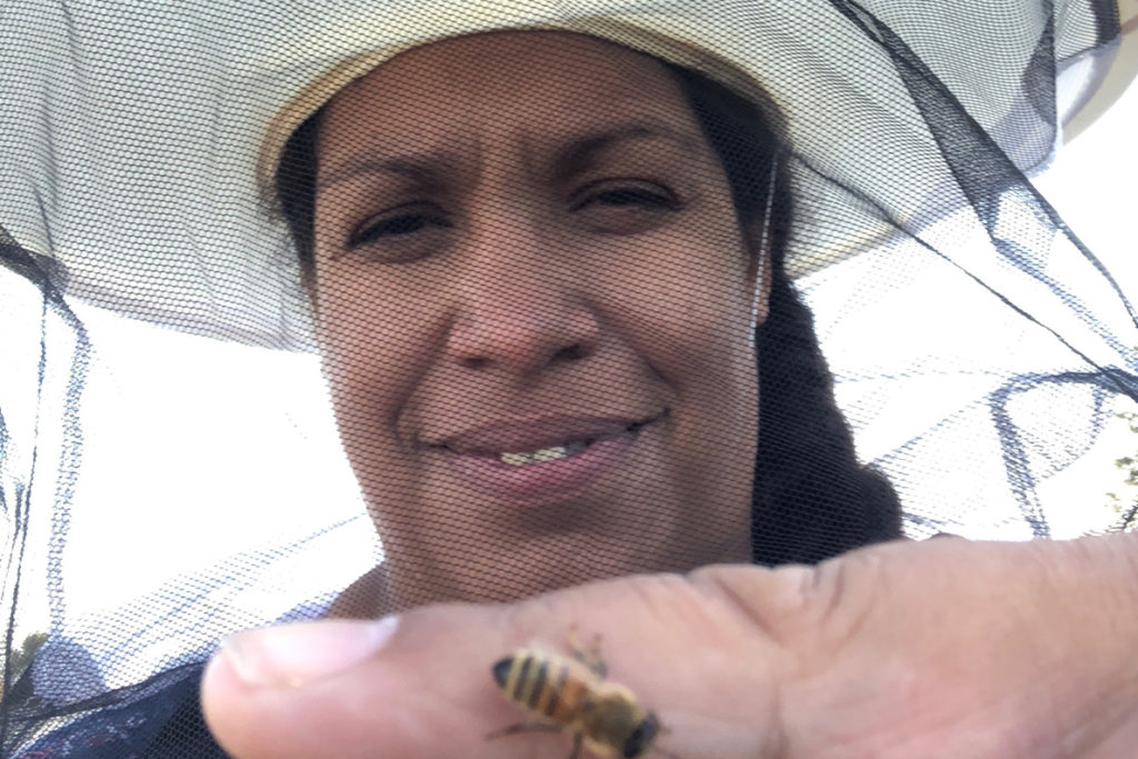Melanie Kirby holding a bee on her finger.