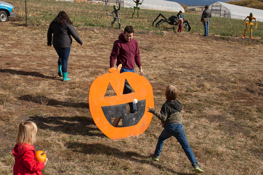 Kids playing pumpkin toss.