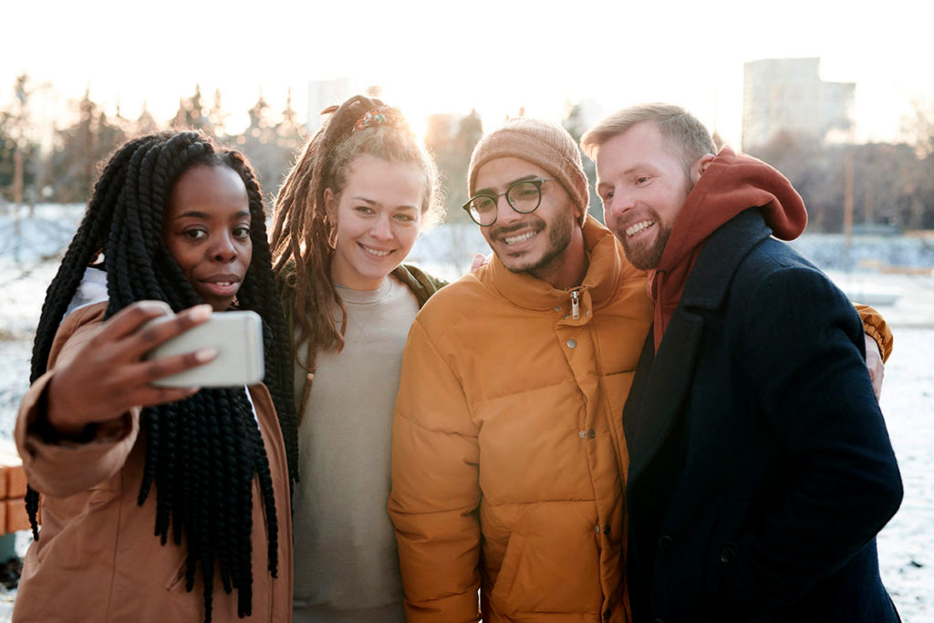 Four people taking a selfie.