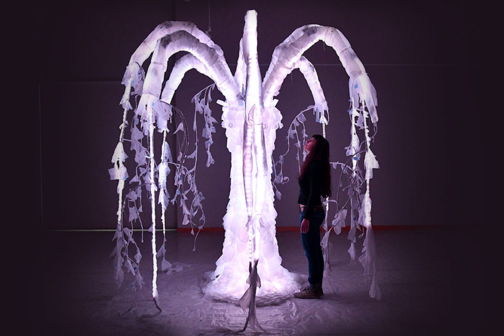 Sena Clara Creston standing beneath her 'Willow of the Waste' sculpture.