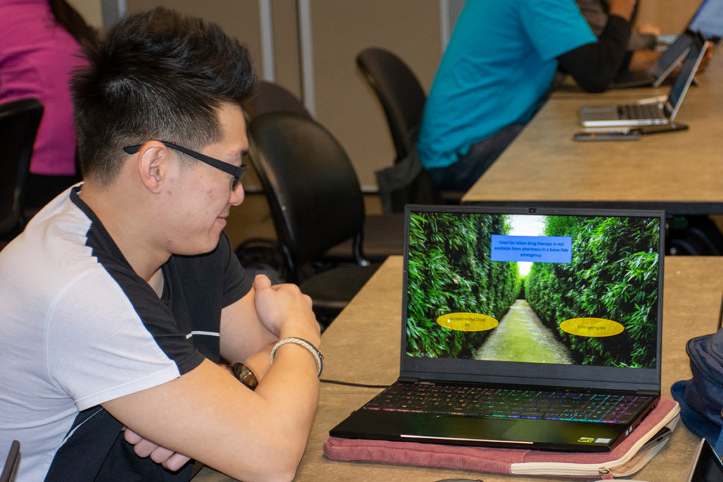 A third year pharmacy student plays an educational game