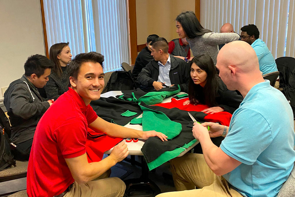 People sitting at tables working on a collaborative service project.