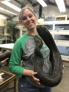 Woman holding a large snake.