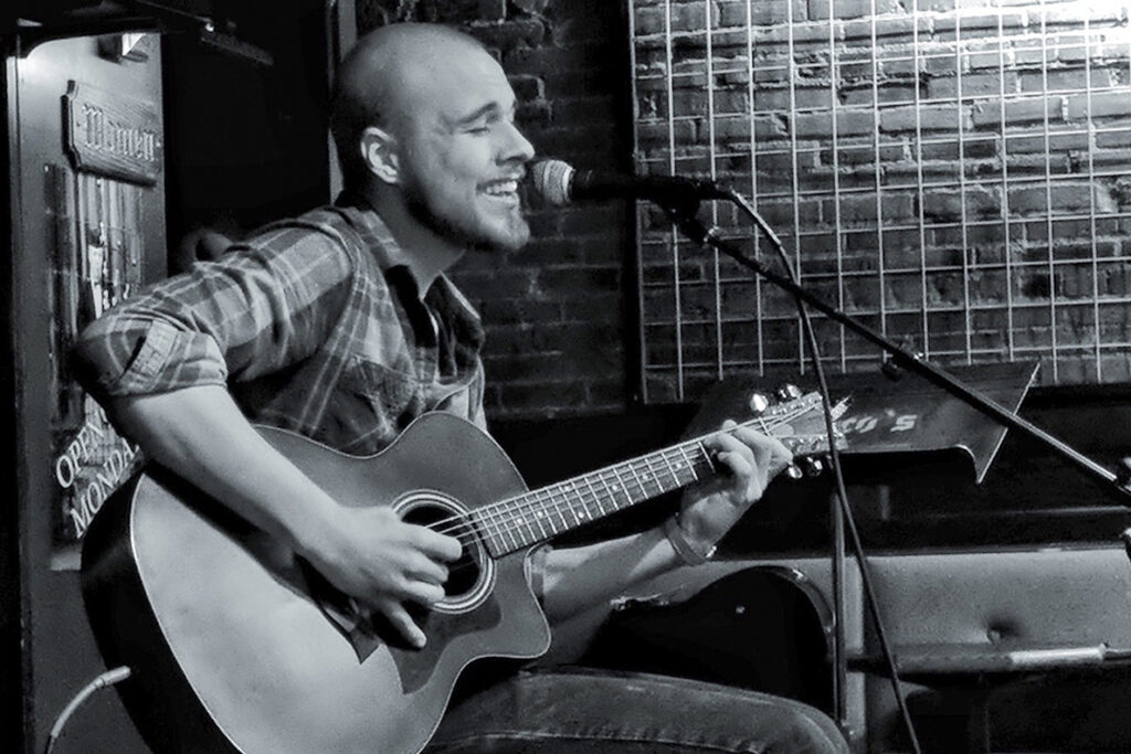 Jacob Wade singing and playing the guitar.