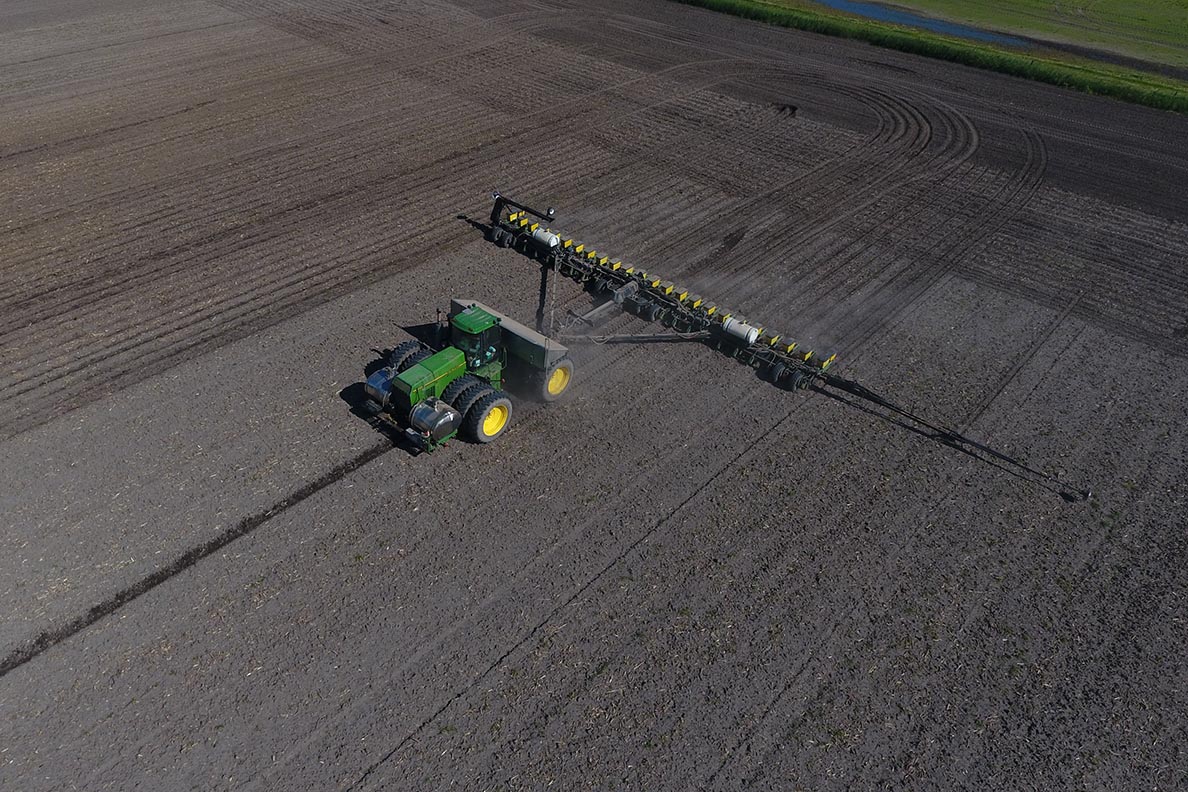a tractor tilling a field of soil viewed from above