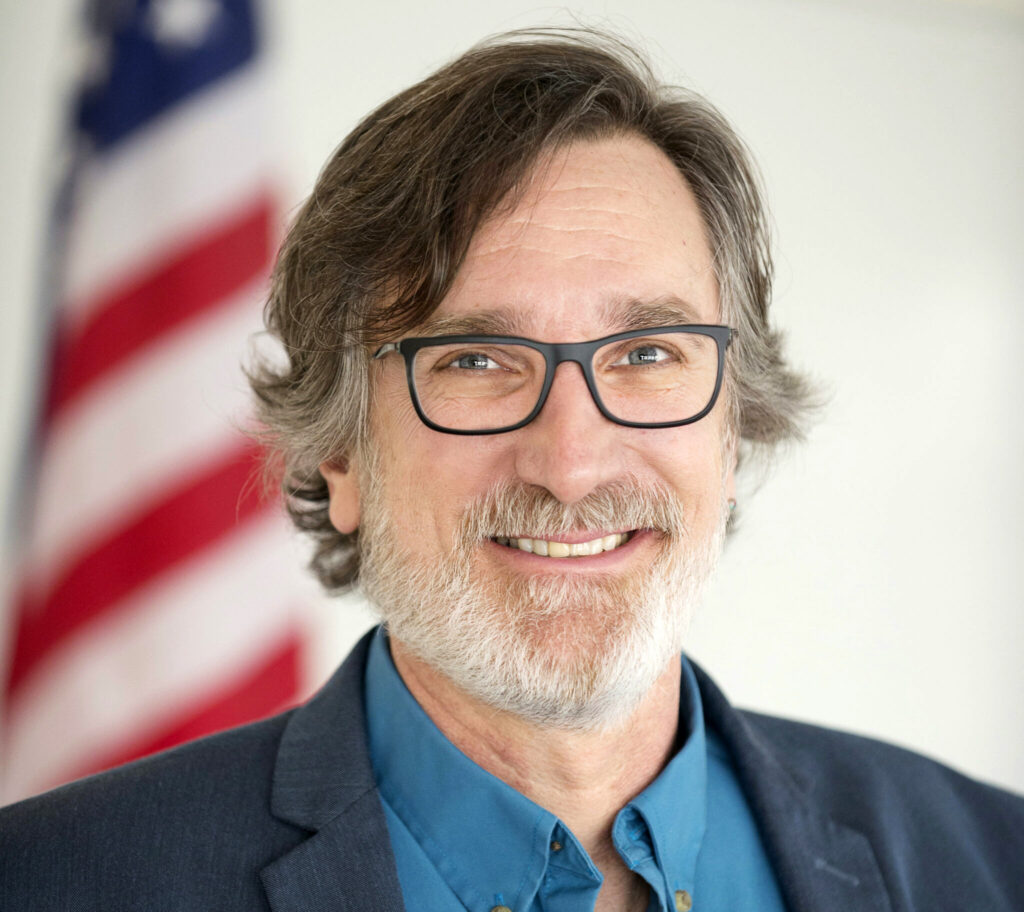 Closeup of Jae Kennedy in front of an American flag.