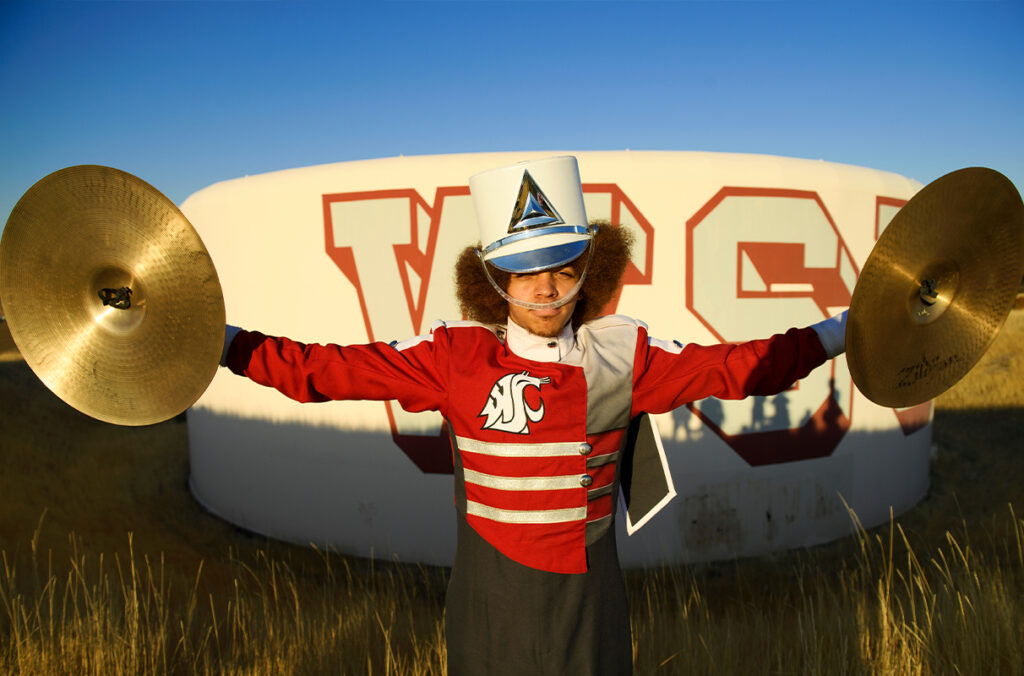 Closeup of Joey McDonald holding cymbals while wearing his marching band uniform.