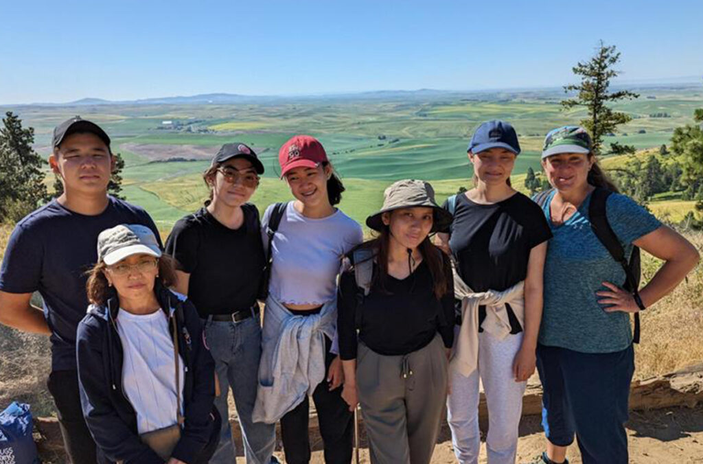 A group of students from Kazakhstan pose for a picture with the Palouse in the background.