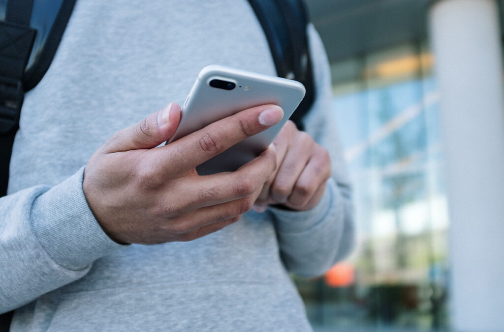 Closeup of a student's hands using a smartphone.
