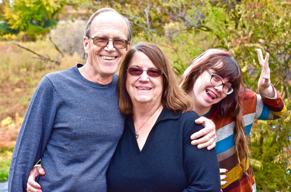 WSU student Jessica Gorman waves from behind her grandparents Michael and Marilyn Gorman, winners of this spring’s Chosen Coug Award.