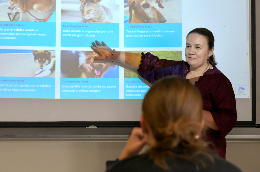 Sonia Lopez-Lopez points toward a projected image of dogs and cats while teaching a class.
