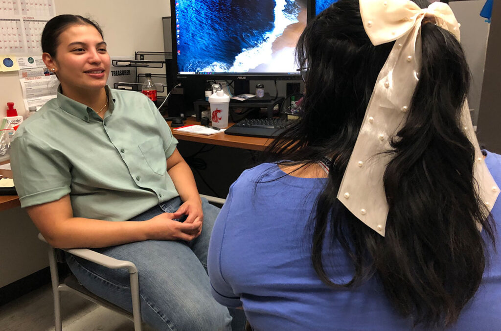 WSU Pullman Benefits Navigator Annalei Santos talks with a student.
