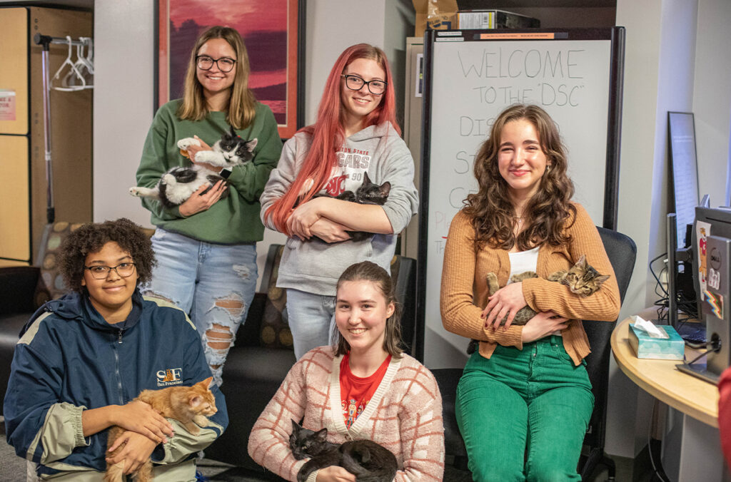 Students hold cats during a Pet Your Stress Away event held in the Disabled Student Center.