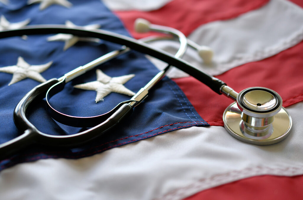Closeup of a stethoscope laying on top of an American flag.