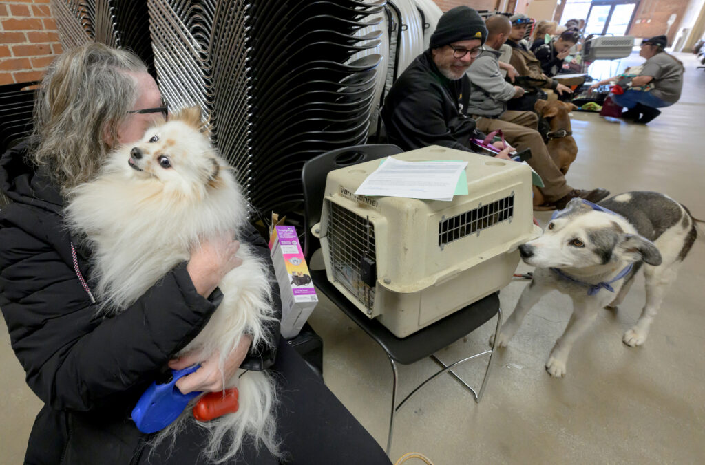 Brenda Dilley holds her dog, Jelly, as they wait in line.