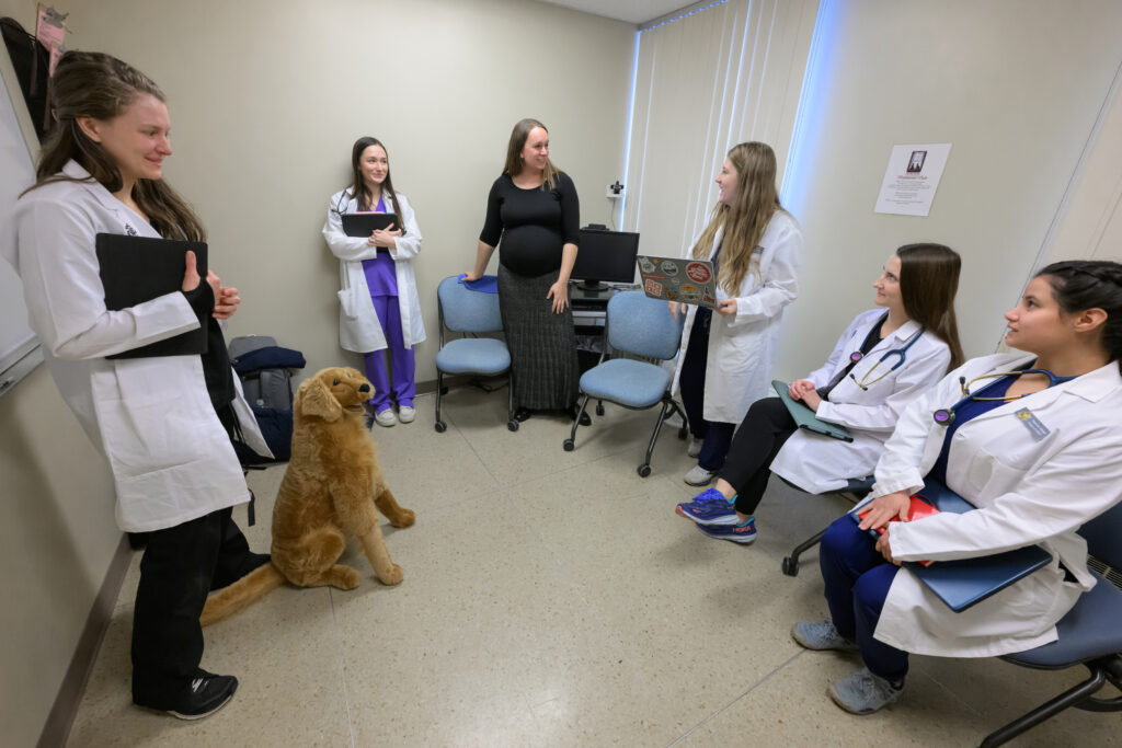 Sarah Calvin, center, a veterinarian who graduated from WSU’s College of Veterinary Medicine, talks with current DVM students as the stand near their simulated canine patient as they take part a Diagnostic Challenge session on Tuesday, Nov. 19, 2024, in Pullman.
